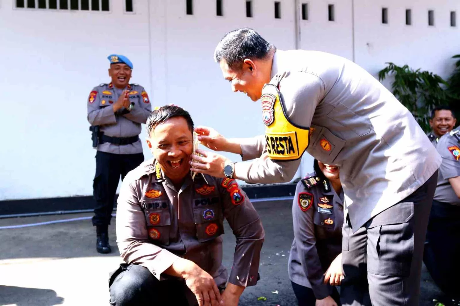 Kapolres Malang Kota saat menyiram air kembang ke badan Kombes Pol Apip Ginanjar. (Hms for BacainD.com)