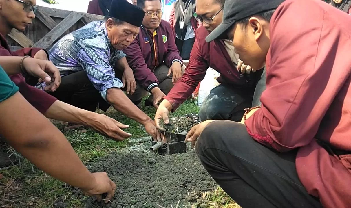mahasiswa bersama warga saat mencoba mencetak limbah plastik dan kaca menjadi paving blok (BM)
