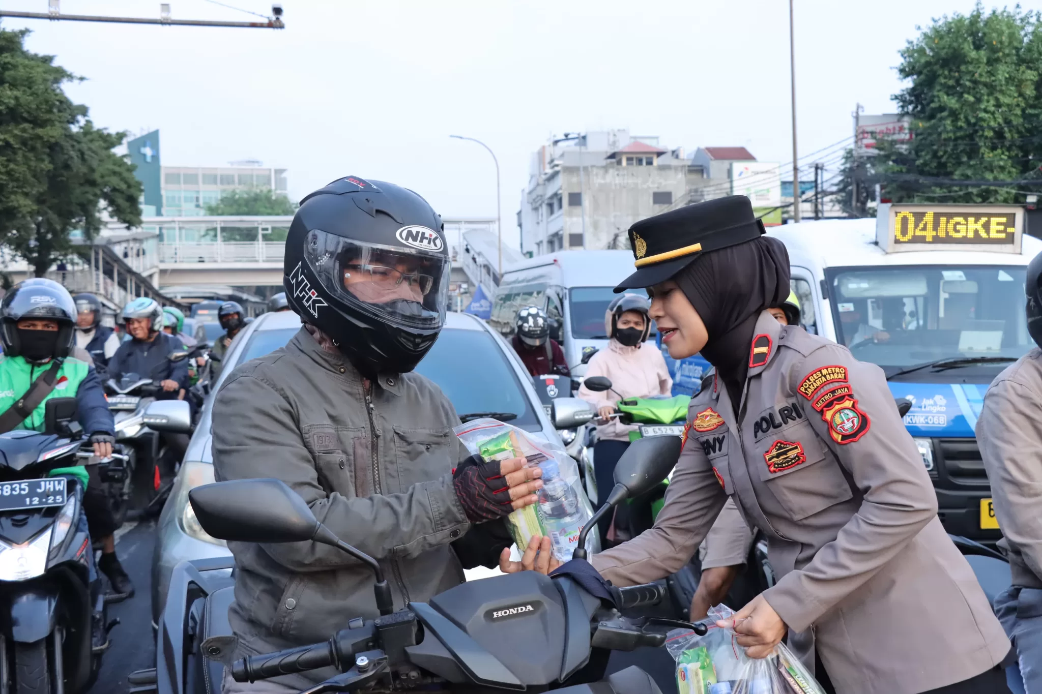 Pengendara Motor Menerima bingkisan coklat dari Polwan. (ist)