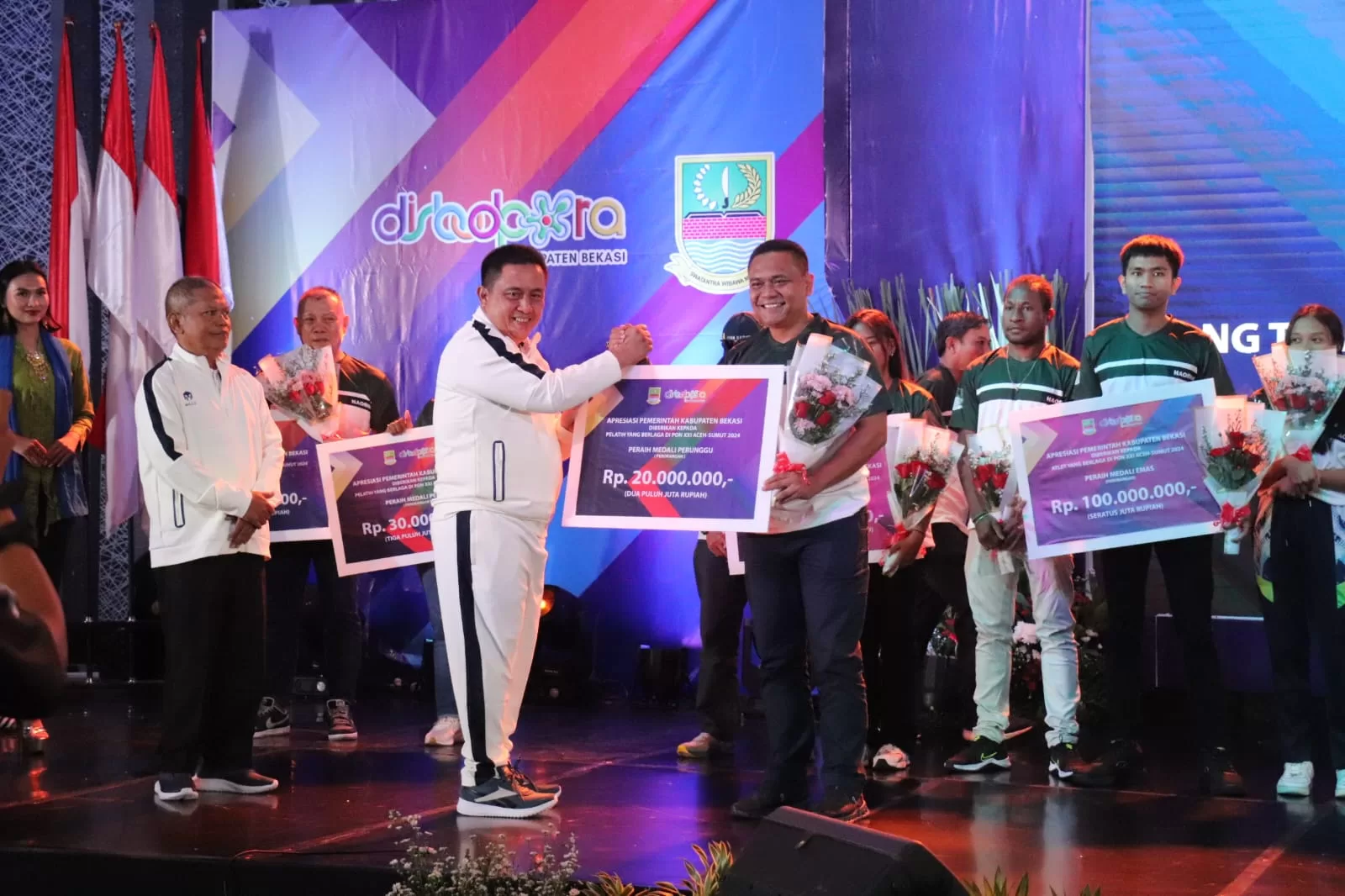 Pj Bupati Bekasi saat memberikan bonus kepada salah satu pelatih atlet peraih medali di PON XXI Aceh-Sumut 2024. (Hms)