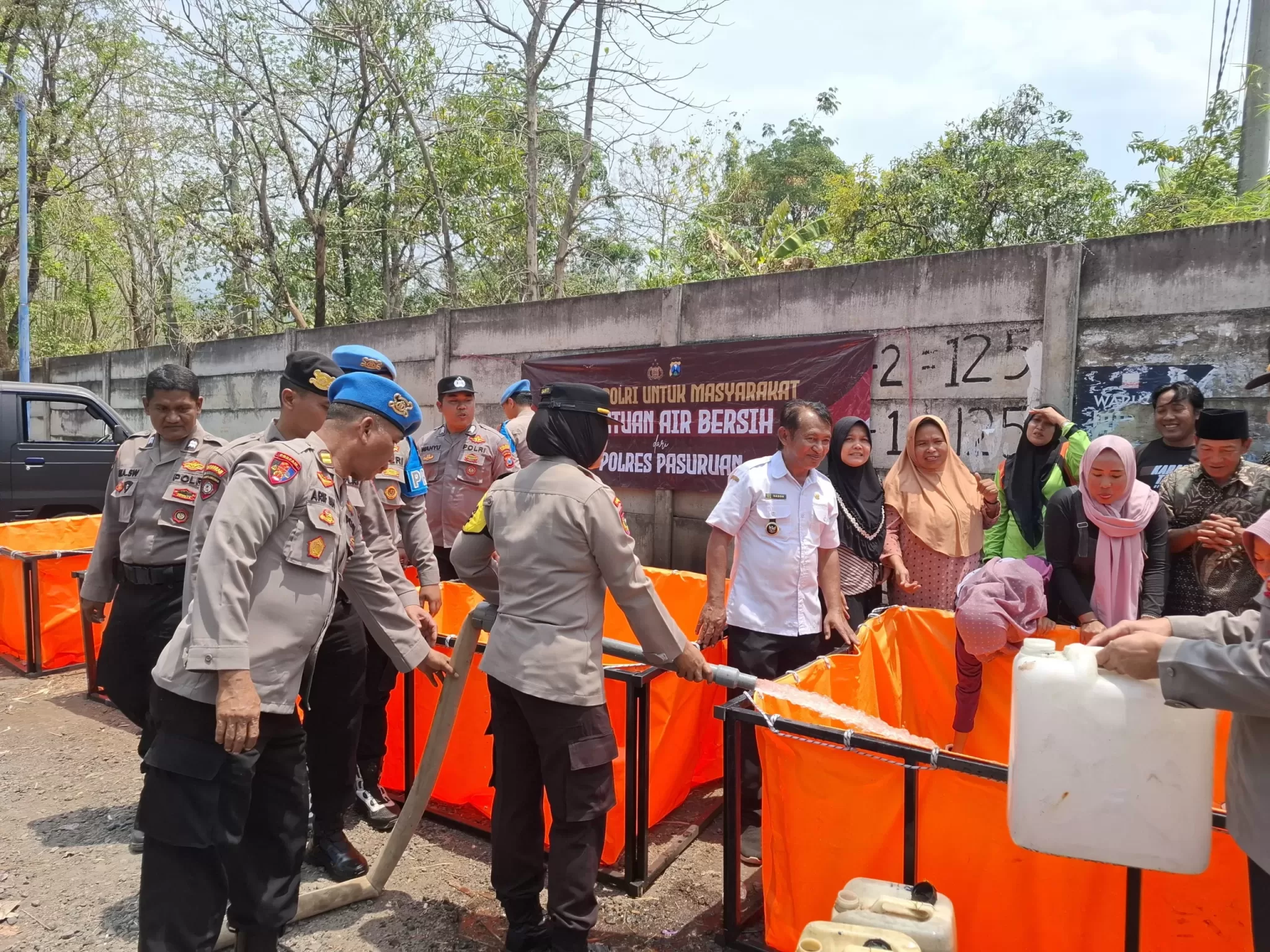polisi saat menungkan air ke bak buatan yang disediakan untuk warga (Humas For Bacaind.com)