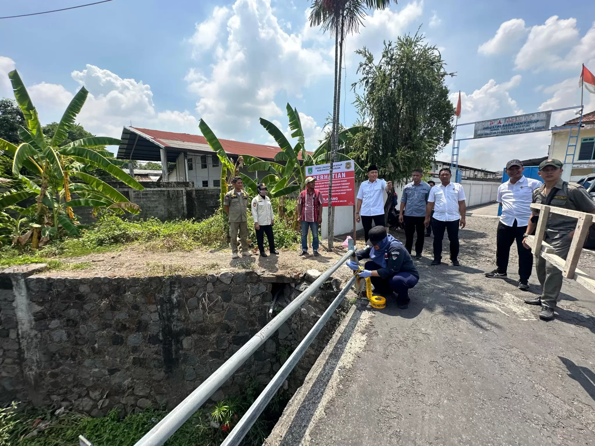 Kepala DLH Kabupaten Pasuruan Taufiqul Ghony bersama petugas saat menutup saluran pembuangan limbah (ist)