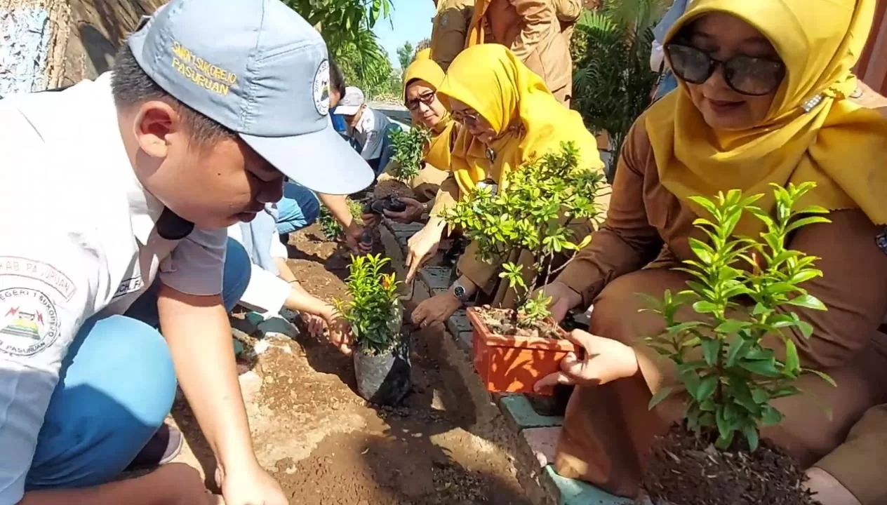 suasana siswa-siswi saat tanam bunga didampingi dewan guru di lingkungan sekolah (BM)