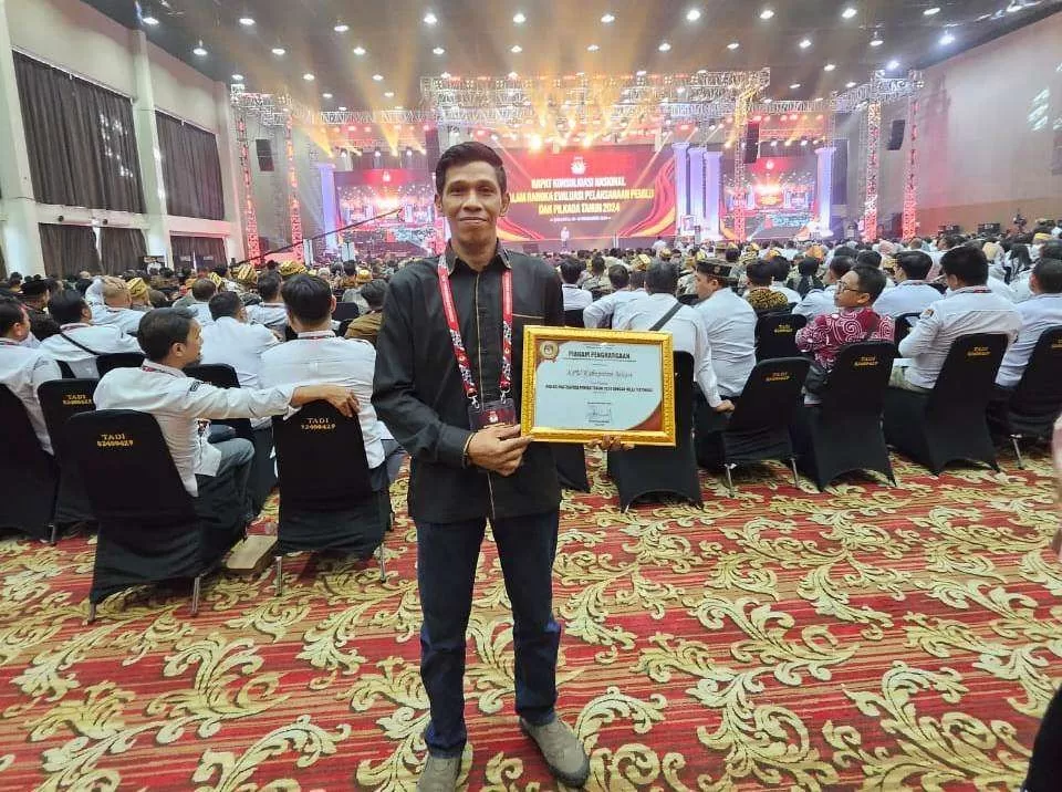 Hasan Badriawan, Anggota KPU Kabupaten Bekasi saat menunjukkan piagam penghargaan dari KPU RI. (Istimewa)