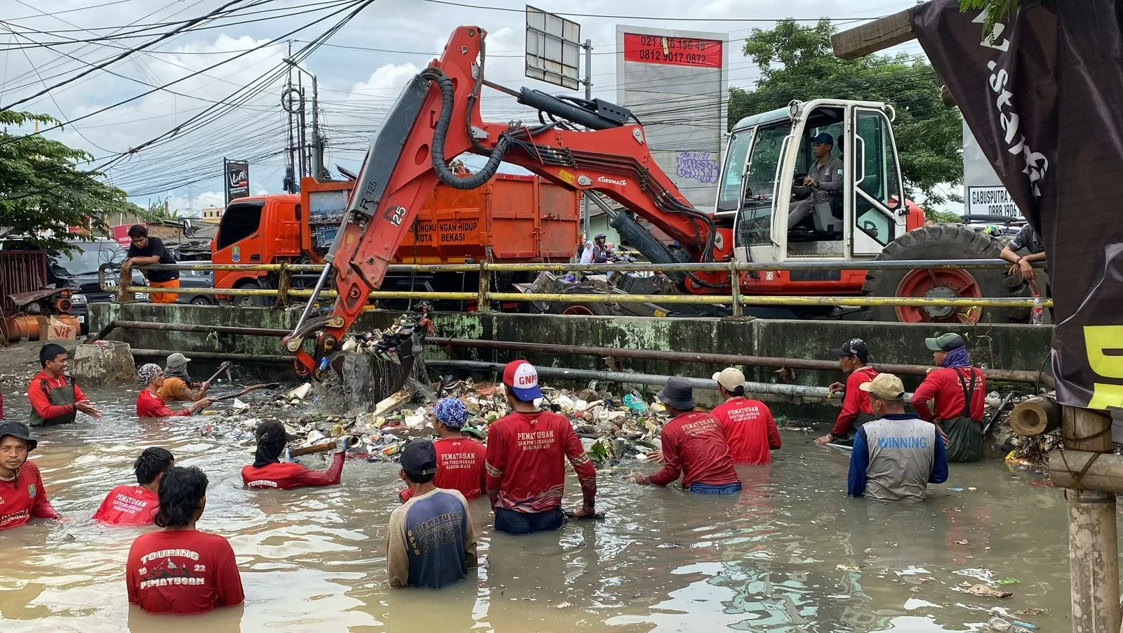 Petugas saat memberikan tumpukan sampah yang menggunung di Kali Teluk Pucung. (Pnd/ist)