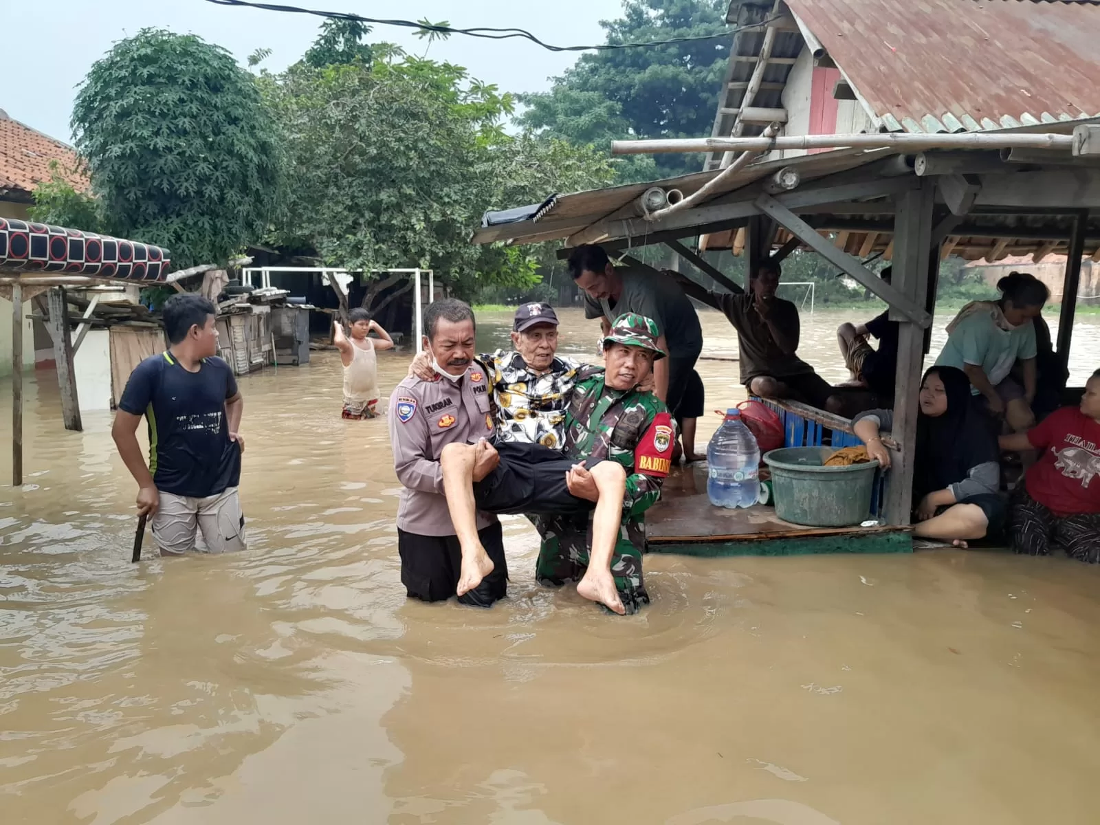 Bhabinkamtibmas dan Babinsah setempat saat mengevakuasi lansia di Bekasi Utara.