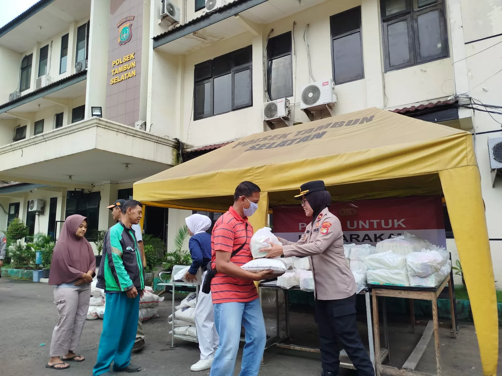 Kapolsek Tambun Selatan saat memberikan paket sembako kepada warga sekitar.