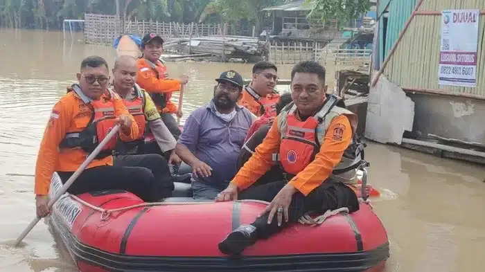 Polisi dan BPBD Kota Bekasi saat mengevakuasi warga yang terjebak banjir. (ist)