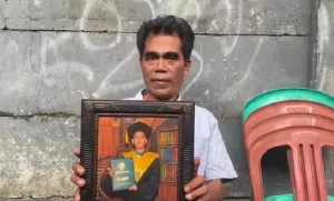 Saifullah Ayah korban saat menunjukkan foto Alm. Sholeh Dermawan. (Ist)