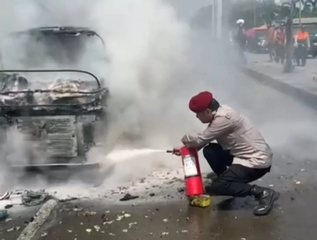 Anggota Kepolisian saat berusaha memadamkan api