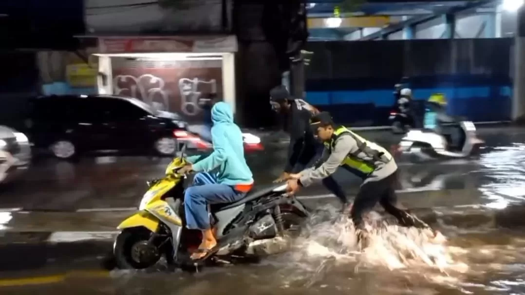 Kapolsek Saat membantu pengendara dorong motor.