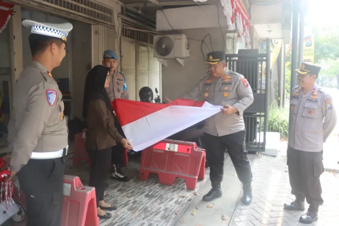 Polres Pasuruan Musnahkan Barang Bukti Hasil Pengungkapan Tindak Kejahatan Tahun 2024 1 Kapolres Pasuruan AKBP Jazuli saat membantu masangkan bendera warga (humas)