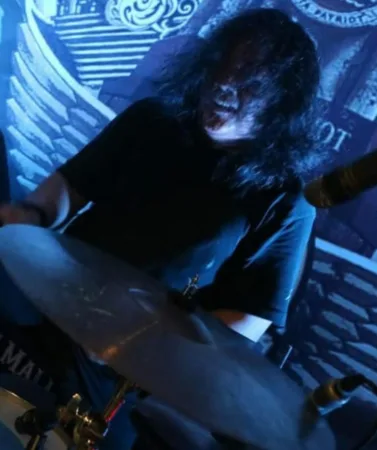Di tengah riuh kota, nama Sambudi, kelahiran April 1963, menjadi bagian penting dalam sejarah musik rock Bekasi. Rambutnya kini memutih, namun semangat bermusiknya tak pernah padam sejak ia menabuh drum pertama kali di era 1980-an.