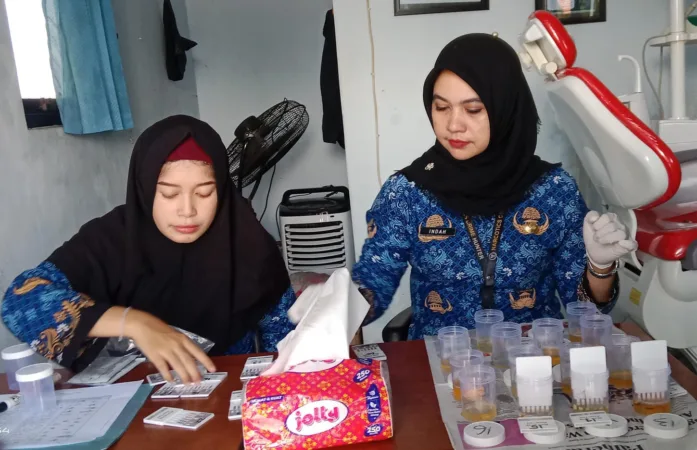 Petugas saat melakukan cek tes urin siswa (BM)
