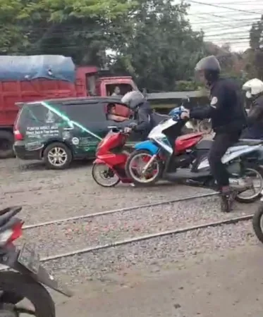 Pengendara Motor harusemgangkat Ban depan untuk melintasi Rel KA Latek Bangil (potongan Video)