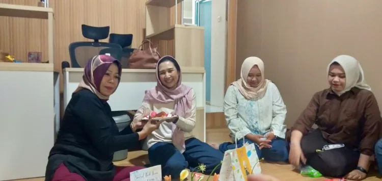 Elisa memyerahkan potongan tumpeng ke Wiwik di Kantor Hukum Bersama (BM)