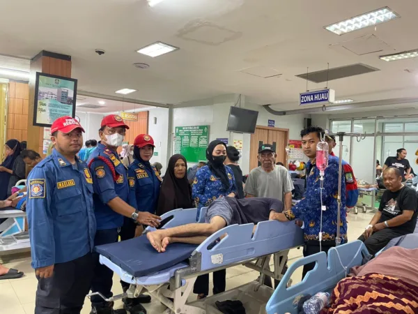 Tim Rescue Kompi A Regu 2 Dinas Pemadam Kebakaran dan Penyelamatan Kota Bekasi mengevakuasi seorang pasien ke RSUD Kota Bekasi pada Senin (27/4/2026).