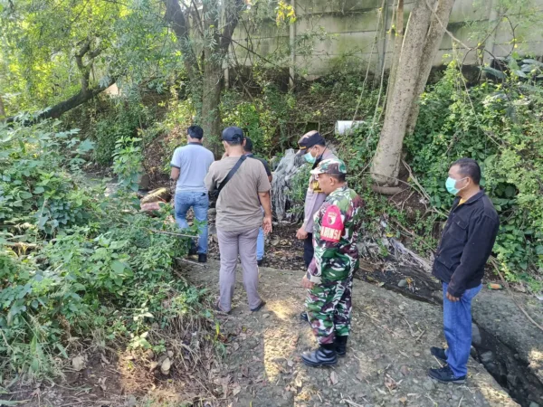 Polisi saat melakukan evakuasi jasad Mr X di Sungai belakang pabrik (hms)