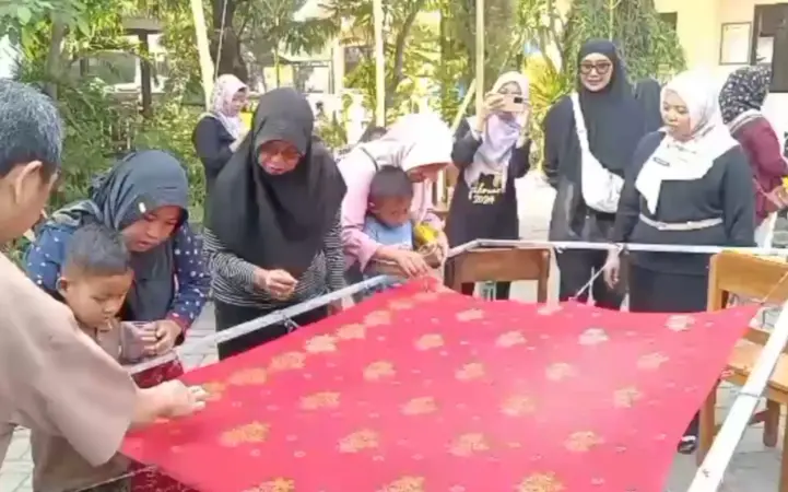 Kepala Sekolah SD Randusari dampingi wali murid dan siswa saat mewarnai kain batik (BM)
