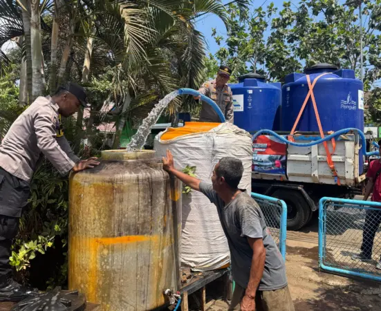 Kapolsek Sumberpucung saat mendistribusikan air bersih (BM/