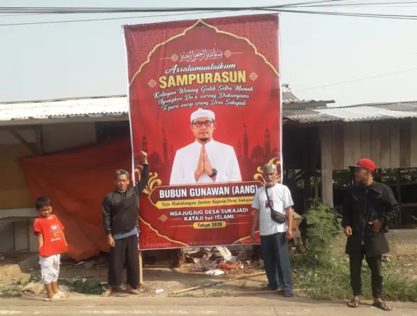 Tim sukses saat memasang banner calon kades (Suryo ST)